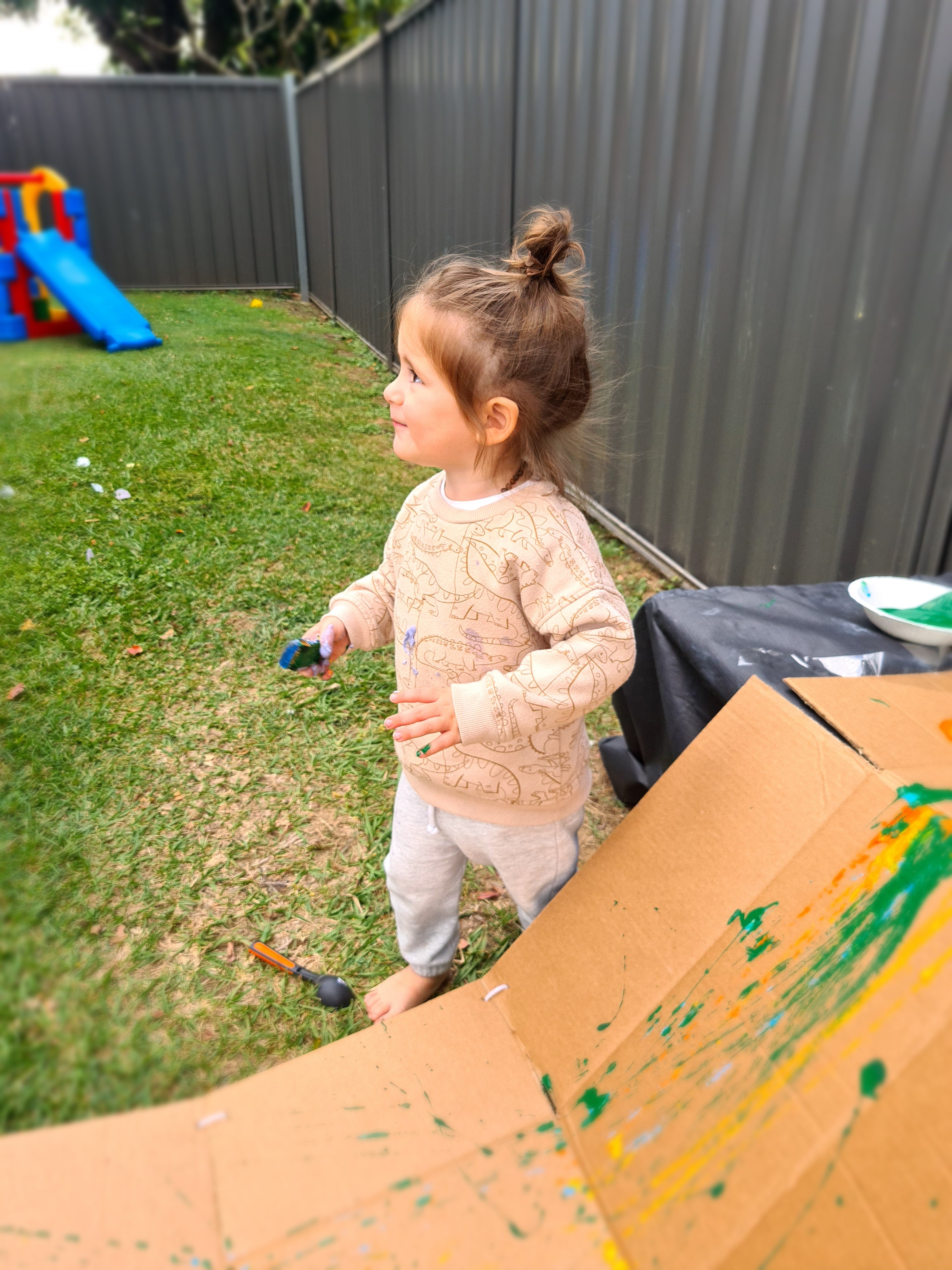 Child painting with cars at messy play class