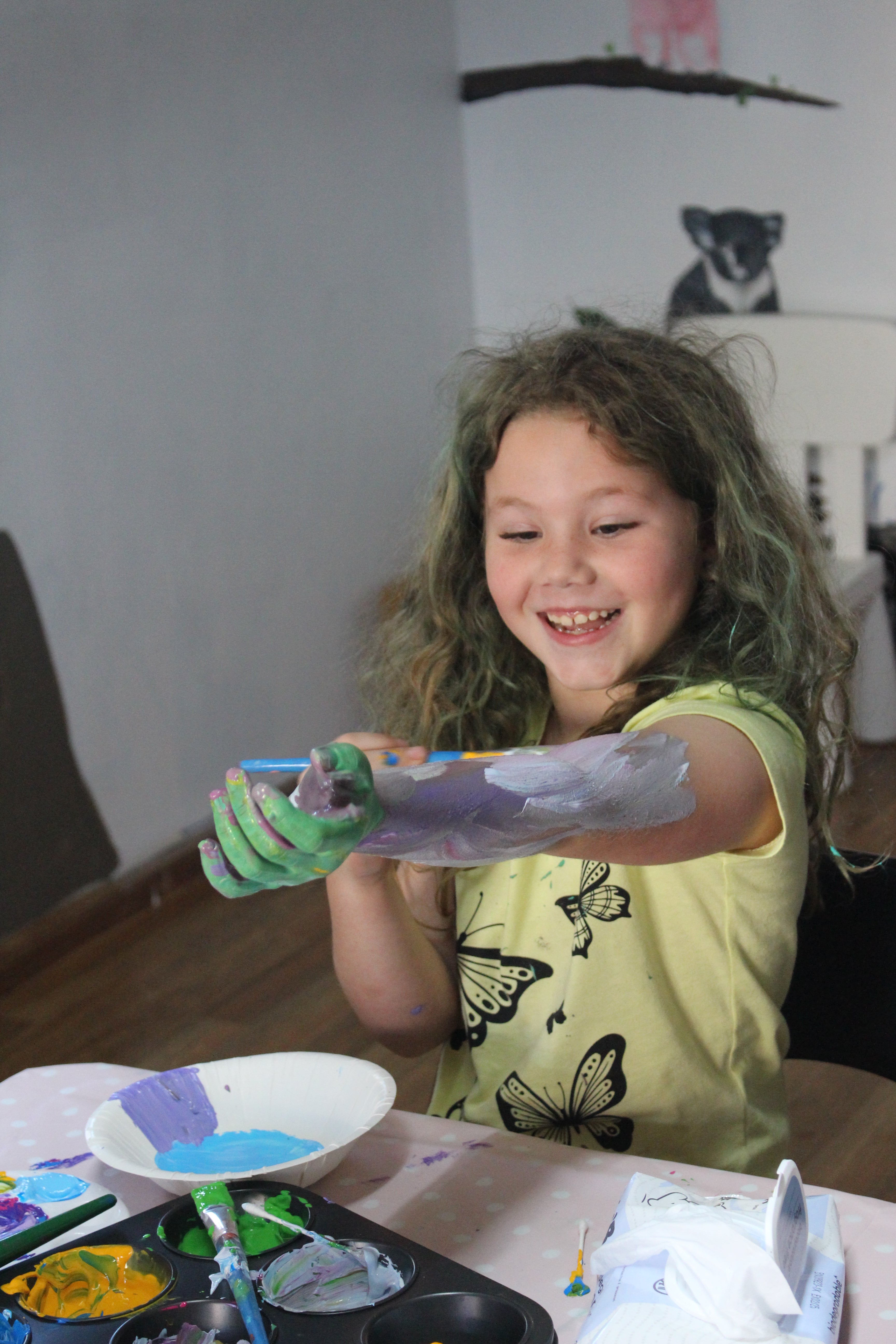 Happy child painting their arm