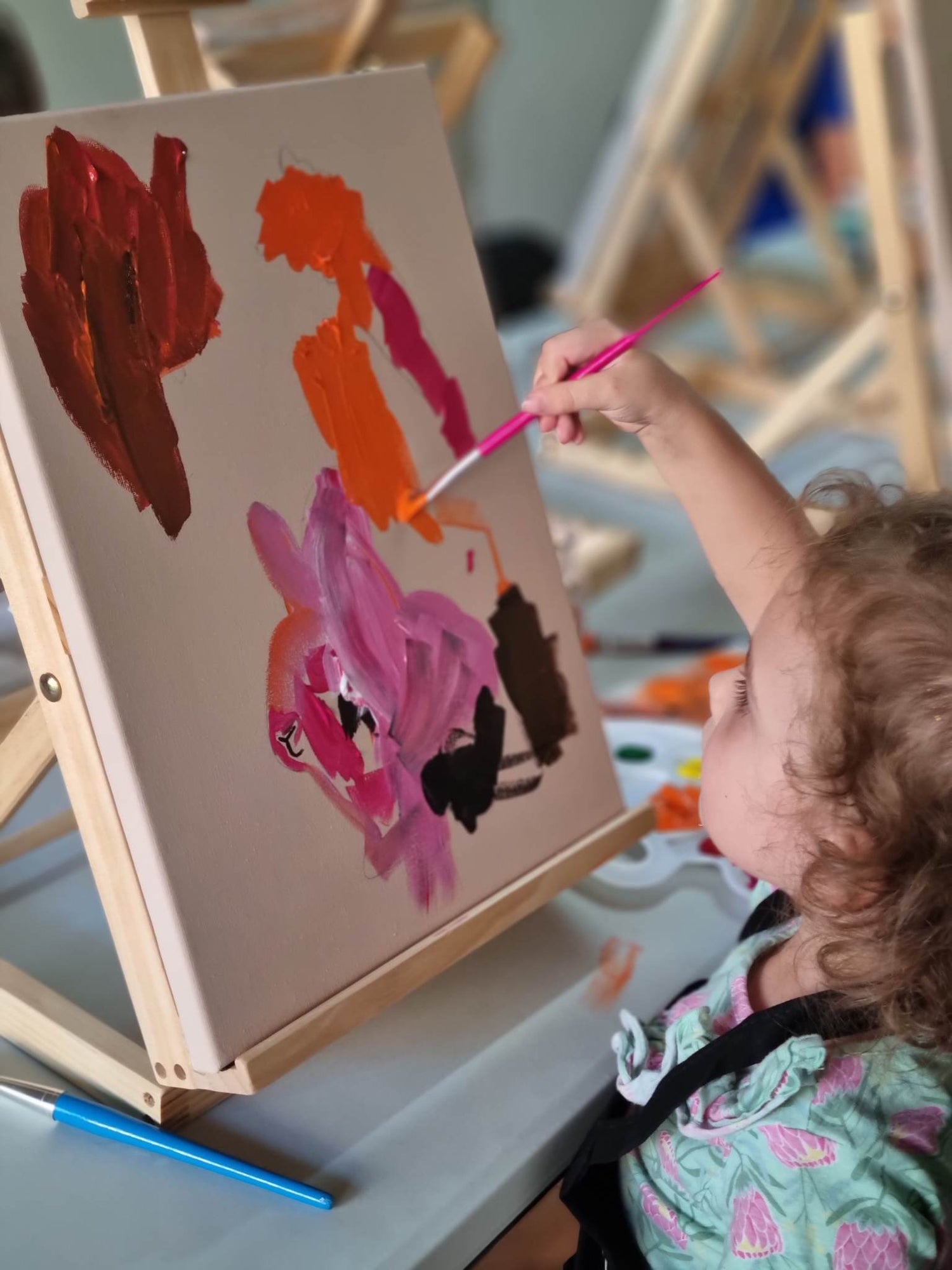 Child painting with bright colours